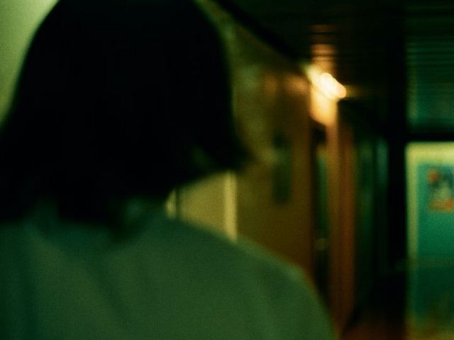 Woman from behind in a dark corridor
