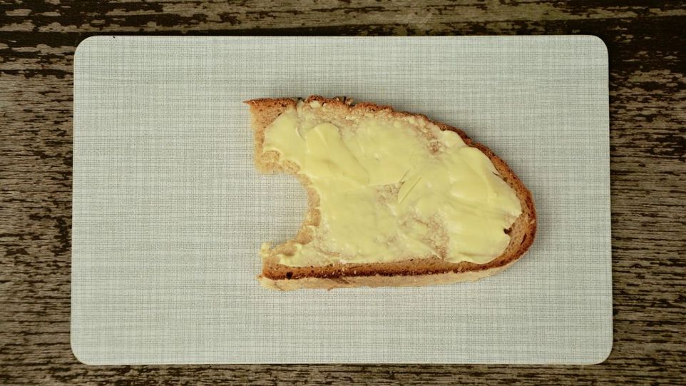 Angebissenens Butterbrot auf einem Frühstücksbrettchen.