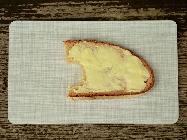 Angebissenens Butterbrot auf einem Frühstücksbrettchen.