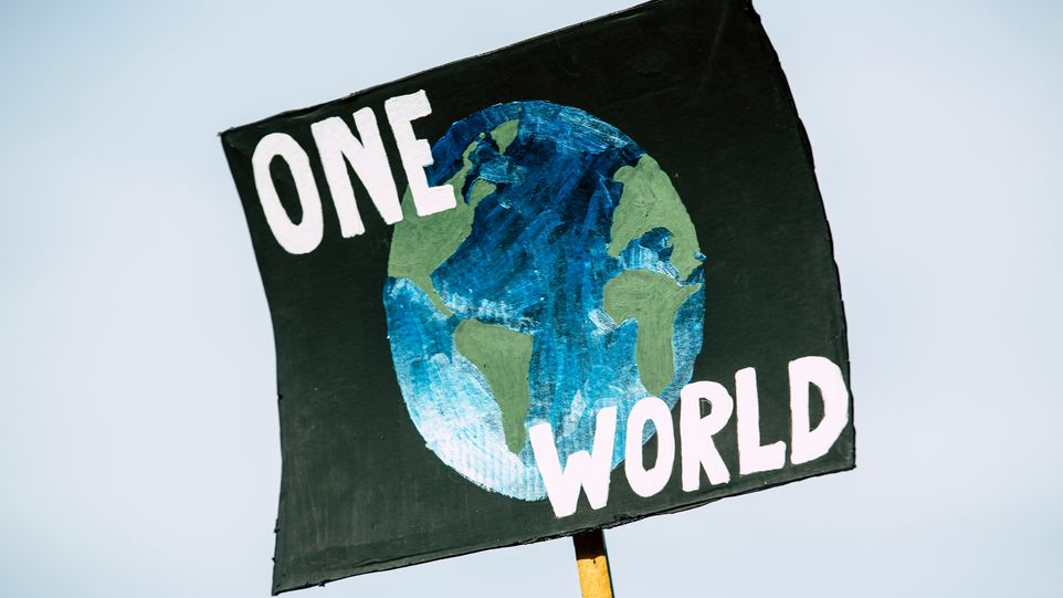 Plakat mit der Aufschrift "One World" und der Zeichnung einer Erde