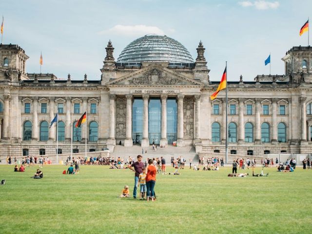Bundestag, im Vordergrund Menschen auf der Wiese