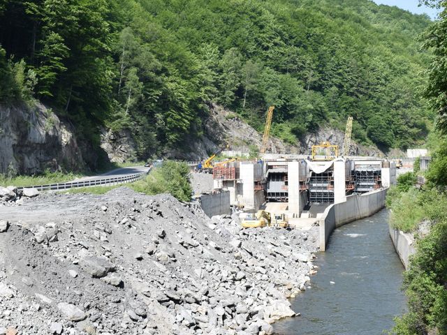 Rumänisches Wasserkraftwerk an einem kleinen Fluss, umgeben von grünen Bäumen